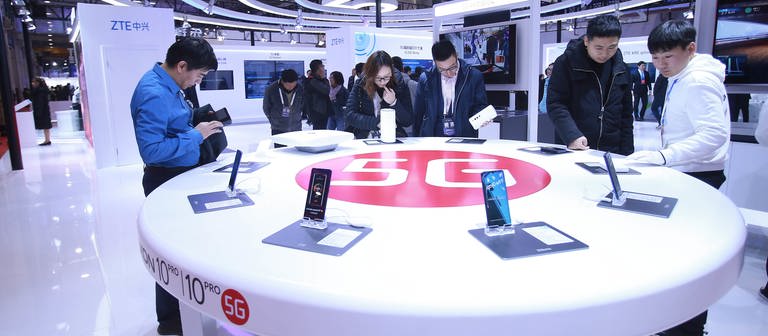 Besucher schauen in Peking neue Smartphones mit 5G-Technologie an. (Foto: dpa Bildfunk, picture alliance/dpa/SIPA Asia via ZUMA Wire | Chen Xiaogen)