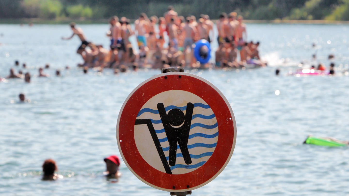 Ein Schild warnt im Badesee Schwimmerinnen und Schwimmer vor einem stark abfallenden Ufer