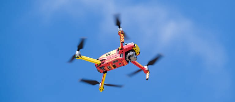 Eine rot-gelbe Drohne schwebt im Himmel (Foto: picture-alliance / Reportdienste, picture alliance/dpa | Ole Spata)