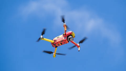 Eine rot-gelbe Drohne schwebt im Himmel (Foto: picture-alliance / Reportdienste, picture alliance/dpa | Ole Spata)