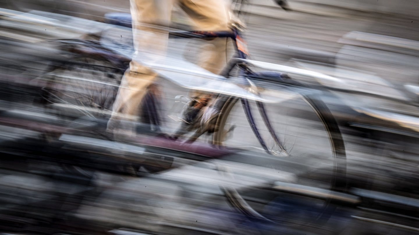Polizist in Stuttgart leiht sich Fahrrad von einem Passanten um zwei Rollerfahrer zu verfolgen. (Foto: dpa Bildfunk, picture alliance/dpa | Sina Schuldt)