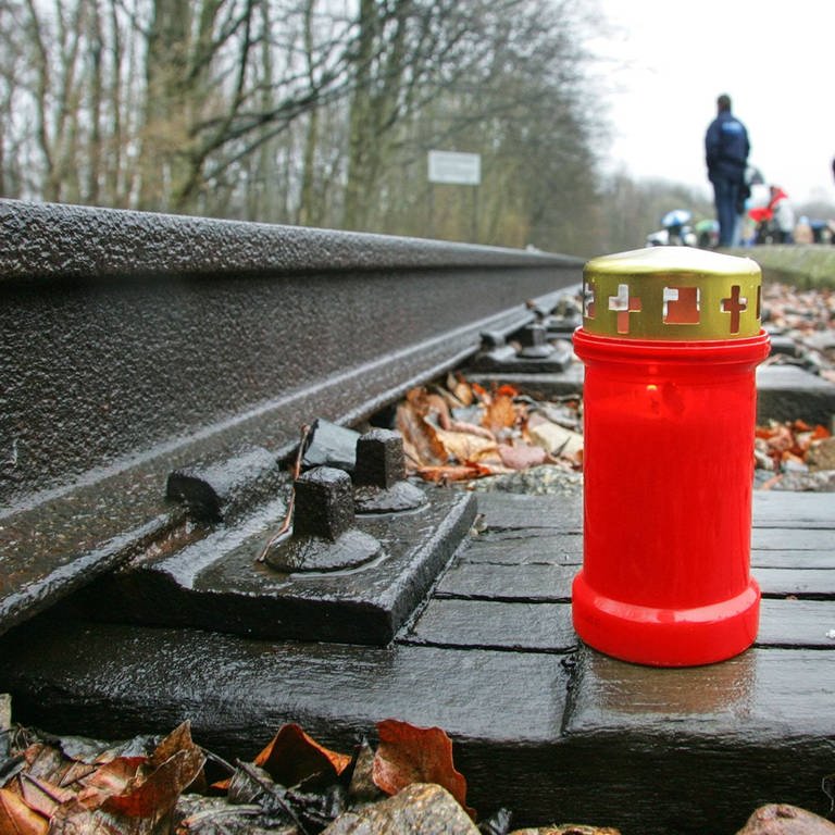 Eckehard Schulz (Foto: IMAGO, Eine Kerze steht am Gleis des Lager-Bahnhofs im ehemaligen Konzentrationslager Buchenwald)