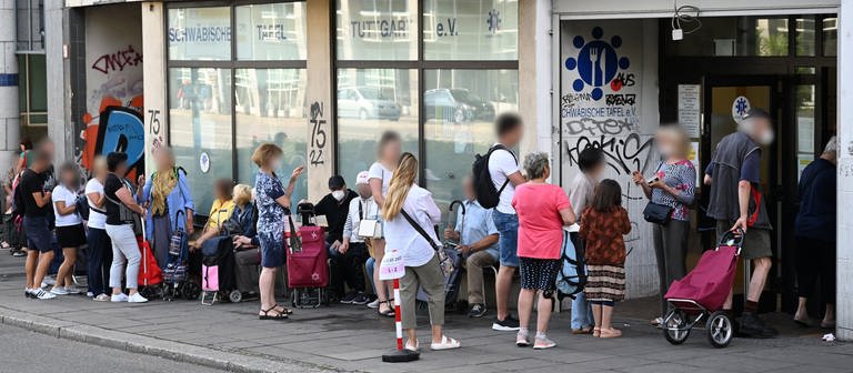 Menschen stehen in einer Schlange und warten vor einem Tafelladen. (Foto: picture-alliance / Reportdienste, picture alliance/dpa | Bernd Weißbrod)