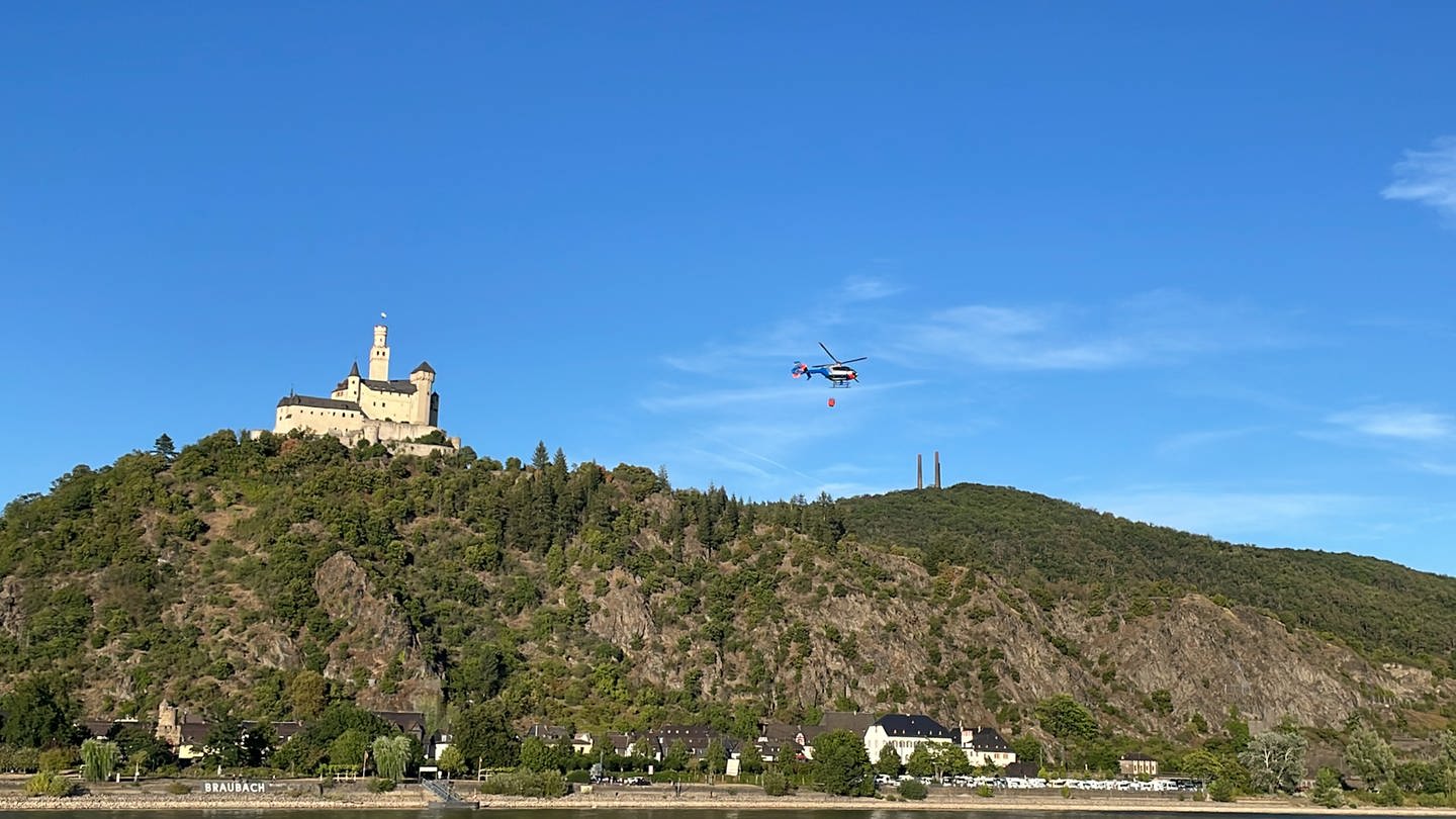 Ein Hubschrauber bekämpft mit einem Löschsack einen Waldbrand bei Braubach.