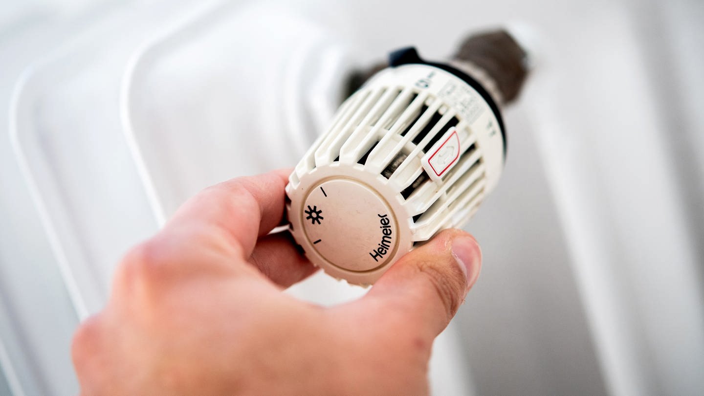 Ein Mann dreht in einer Wohnung am Thermostat einer Heizung. (Foto: DASDING, picture alliance/dpa | Hauke-Christian Dittrich)