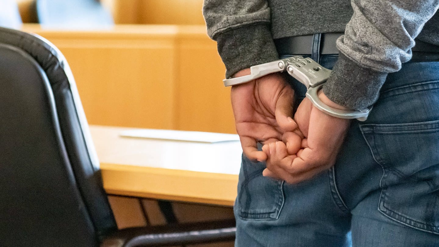 Symbolbild: Angeklagter mit Handschellen im Gerichtssaal (Foto: DASDING, IMAGO / Jan Huebner)
