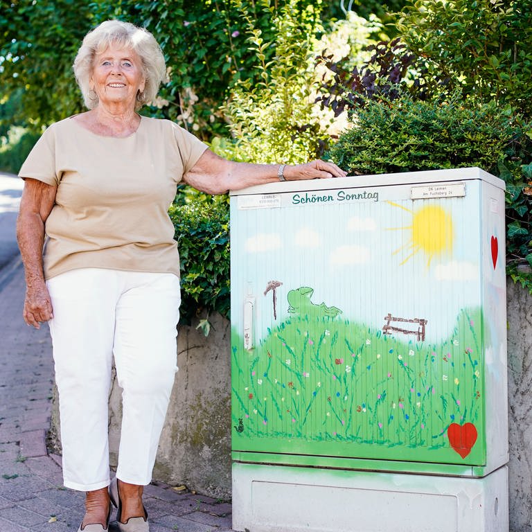 Inge Hess steht vor dem Wohnhaus neben einem von ihr mit Graffiti bemalten Stromkasten. (Foto: picture-alliance / Reportdienste, picture alliance/dpa | Uwe Anspach)