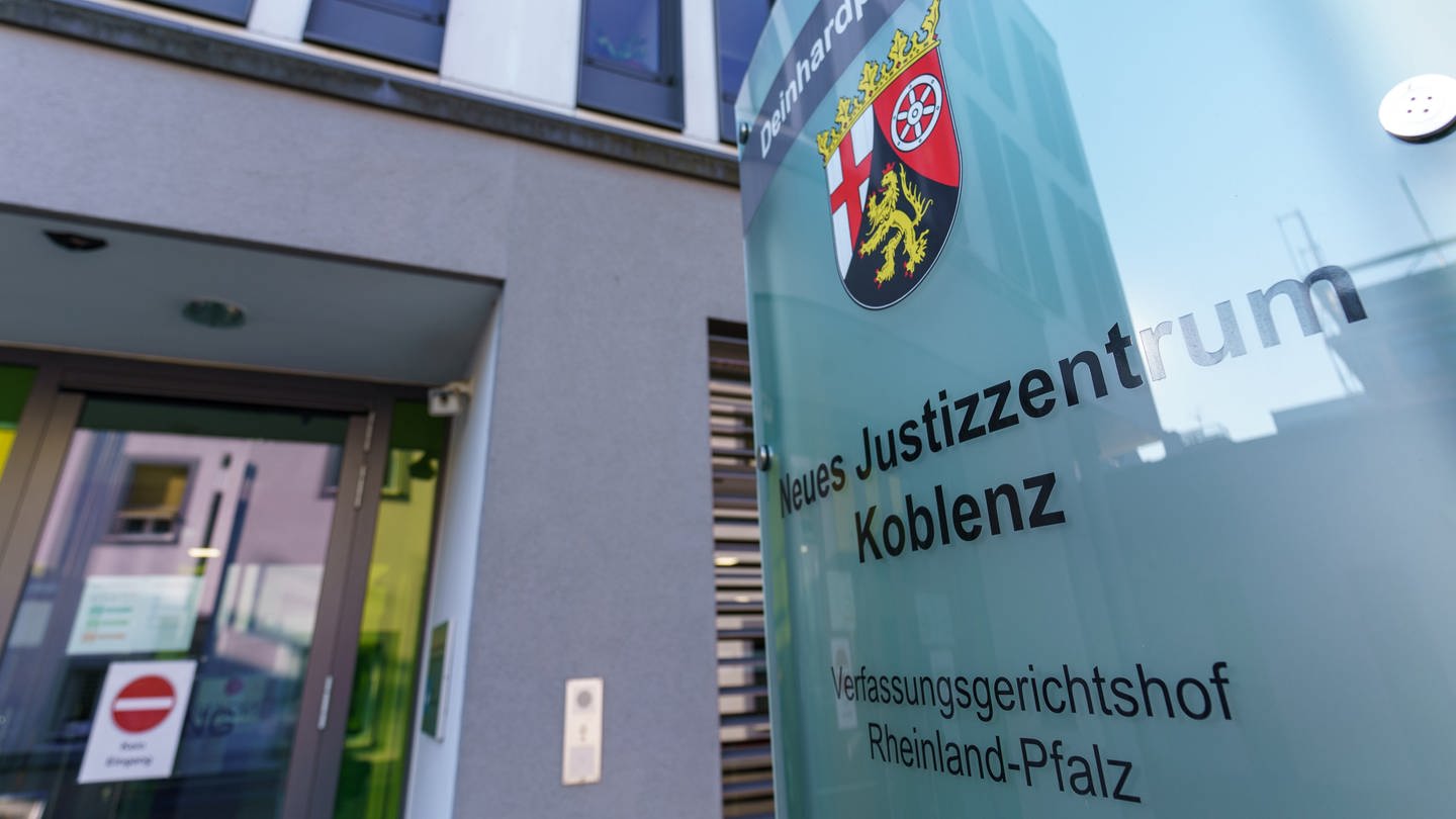 Am Gerichtsgebäude ist ein Hinweis „Neues Justizzentrum Koblenz Verfassungsgerichtshof Rheinland-Pfalz“ angebracht.
