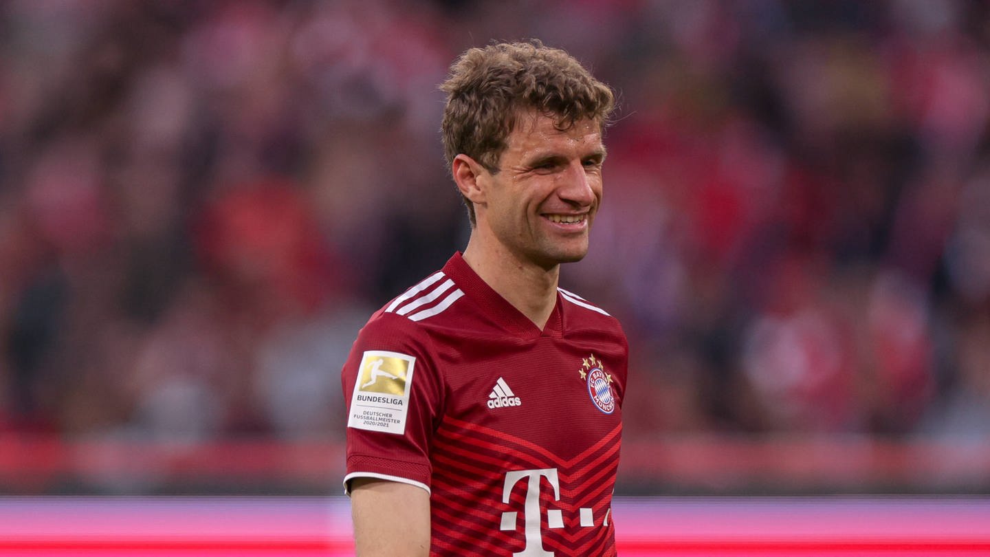 Thomas Müller lächelt im Bayern-Trikot auf dem Spielfeld