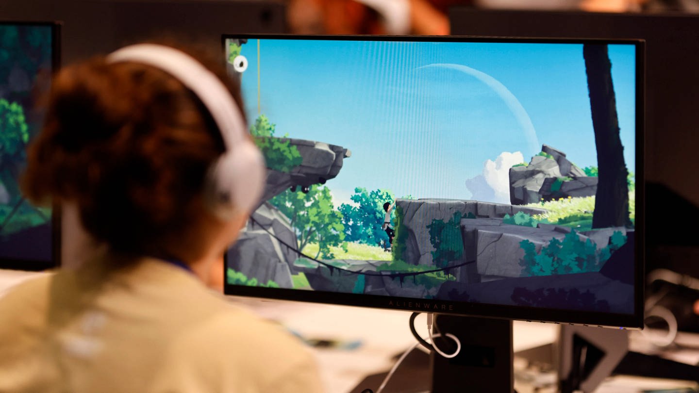Besucherin spielt ein Computerspiel auf der Gamescom 2022. (Foto: IMAGO, IMAGO / Panama Pictures)