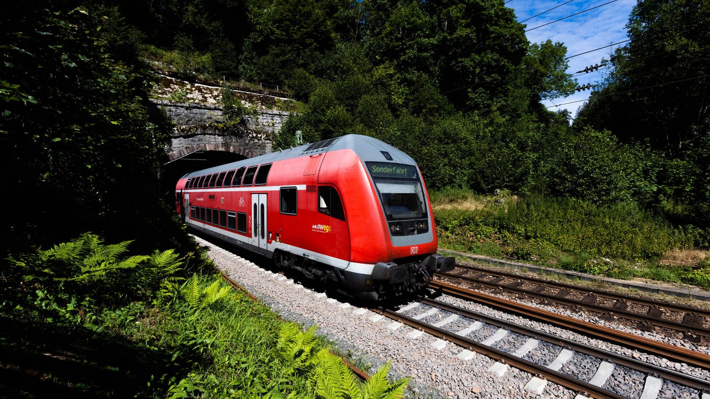Ein Doppelstockzug der Deutschen Bahn fährt auf der Strecke der Schwarzwaldbahn auf den Gleisen.