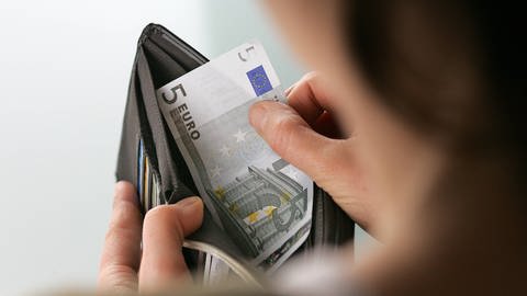 Eine Frau nimmt Geldscheine aus einem Portemonaie (Foto: IMAGO, IMAGO / photothek)
