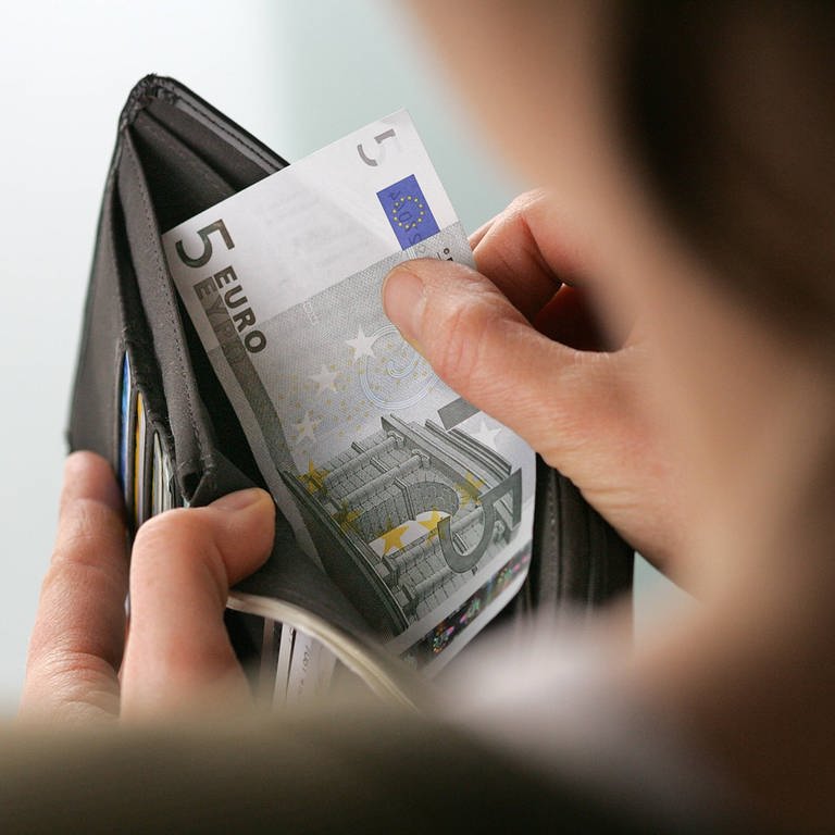 Eine Frau nimmt Geldscheine aus einem Portemonaie (Foto: IMAGO, IMAGO / photothek)