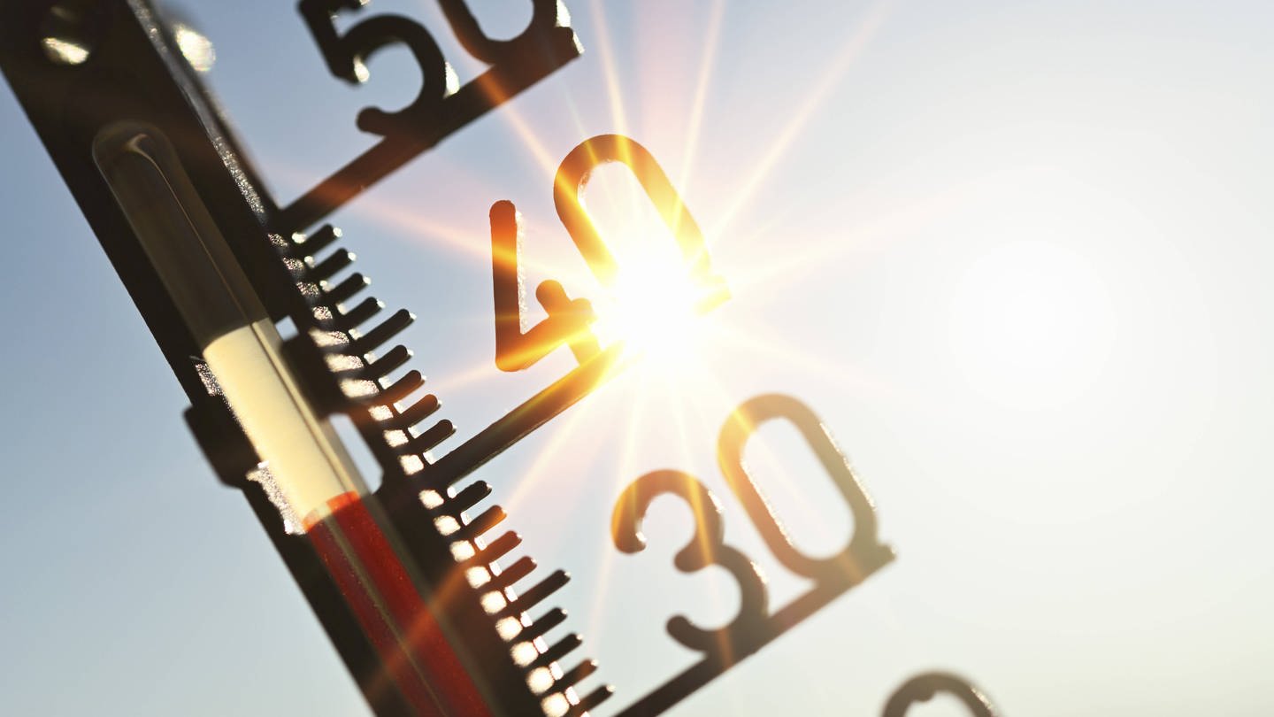 FOTOMONTAGE, Thermometer mit Sonnenstrahlen, Symbolfoto