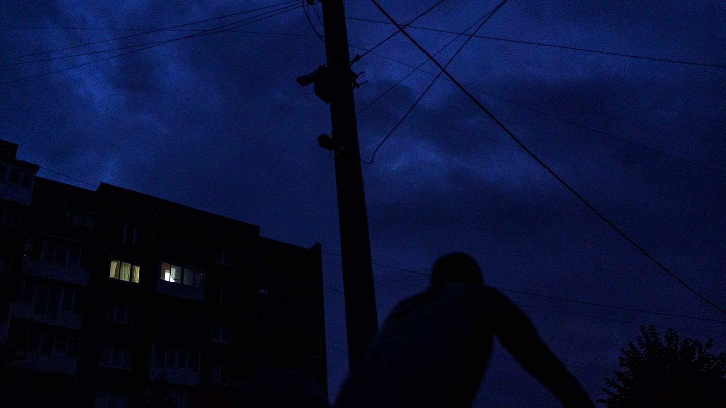 Ein Fahrradfahrer fährt an einem dunklen Haus vorbei (Foto: dpa Bildfunk, picture alliance/dpa/AP | David Goldman)