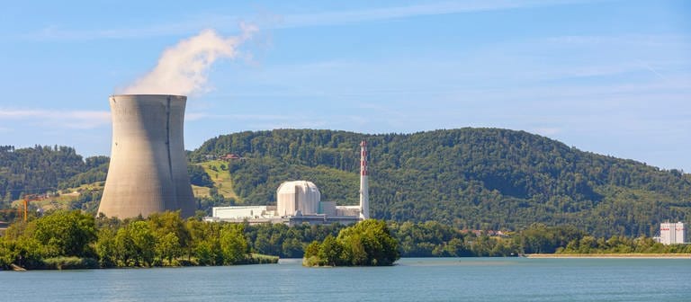 Atomkraftwerk auf der Schweizer Seite des Rheins gegenüber Dogern. Kühlturm links im Bild mit Bergen im Hintergrund und dem Rhein im Vordergrund.  (Foto: IMAGO, IMAGO / Achille Abboud)