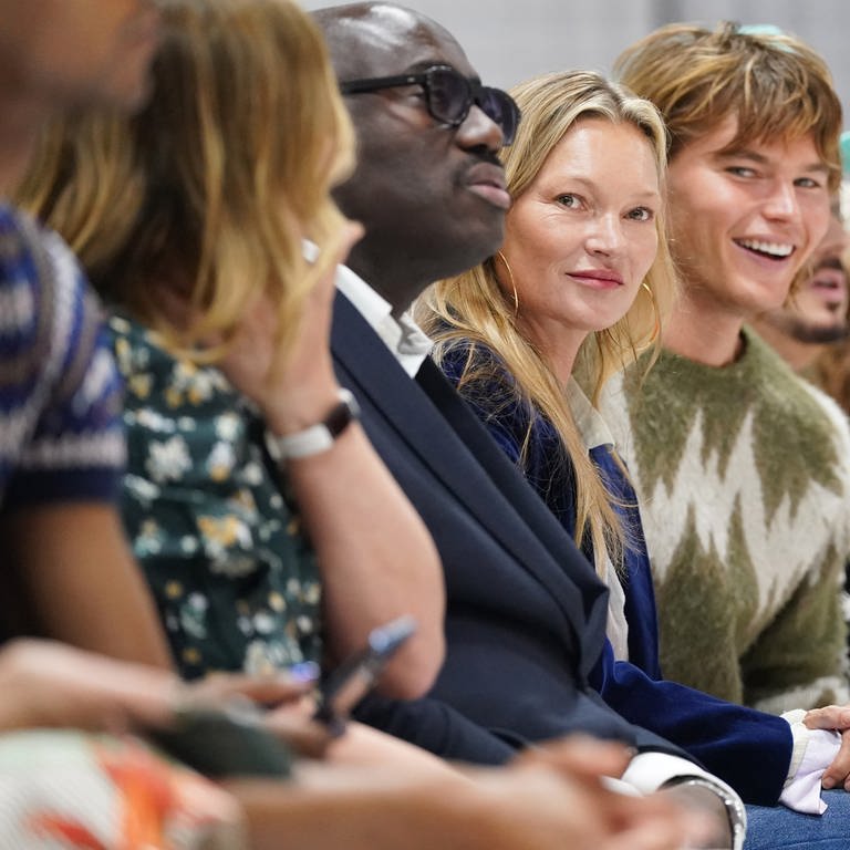 Kate Moss (M) und Jordan Barrett (M, r) beobachten Models während der Richard Quinn Show der London Fashion Week 2021 im Londoner Hotel am Leicester Square. (Foto: dpa Bildfunk, picture alliance/dpa/PA Wire | Jonathan Brady)