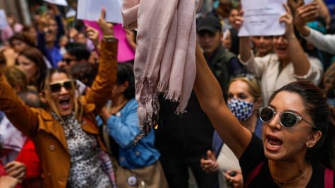 Eine Frau hält ein Kopftuch hoch, während sie mit anderen Demonstrierenden bei einem Protest gegen den Tod der Iranerin Mahsa Amini vor dem iranischen Generalkonsulat Parolen ruft. (Foto: dpa Bildfunk, picture alliance/dpa/AP | Francisco Seco)