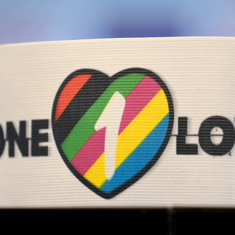 Die spezielle Kapitänsbinde als Zeichen gegen Diskriminierung und für Vielfalt liegt auf einem Tisch. Diese ziert «ein Herz in bunten Farben, die für Vielfalt stehen, sowie die Aufschrift 'One Love'. (Foto: dpa Bildfunk, Picture Alliance)
