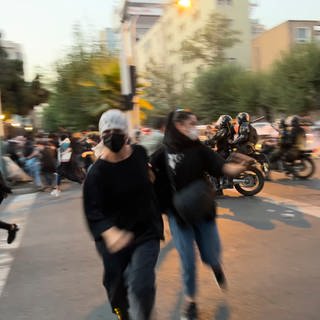 Frauen im Iran fliehen vor der Polizei als sie auf der Straße demonstrieren.  (Foto: dpa Bildfunk, picture alliance/dpa/AP | Uncredited)