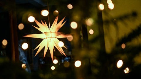 Ein leuchtender Weihnachtsstern hängt an einem Geschäft (Foto: dpa Bildfunk, picture alliance/dpa/dpa-Zentralbild | Britta Pedersen)