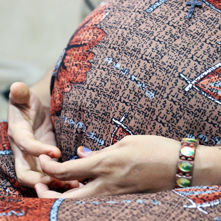 ARCHIV - Leihmutter Arpita Christian hält am 06.05.2014 ihre Hände im Leihmutter-Haus der Akanksha Infertility Clinic in Anand (Indien) vor ihrem Babybauch. (Foto: dpa Bildfunk, picture alliance / dpa | Doreen Fiedler)