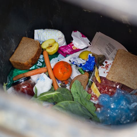 Lebensmittel wie Brot und Salat liegen in einer Mülltonne (Foto: dpa Bildfunk, picture alliance / dpa | Patrick Pleul)