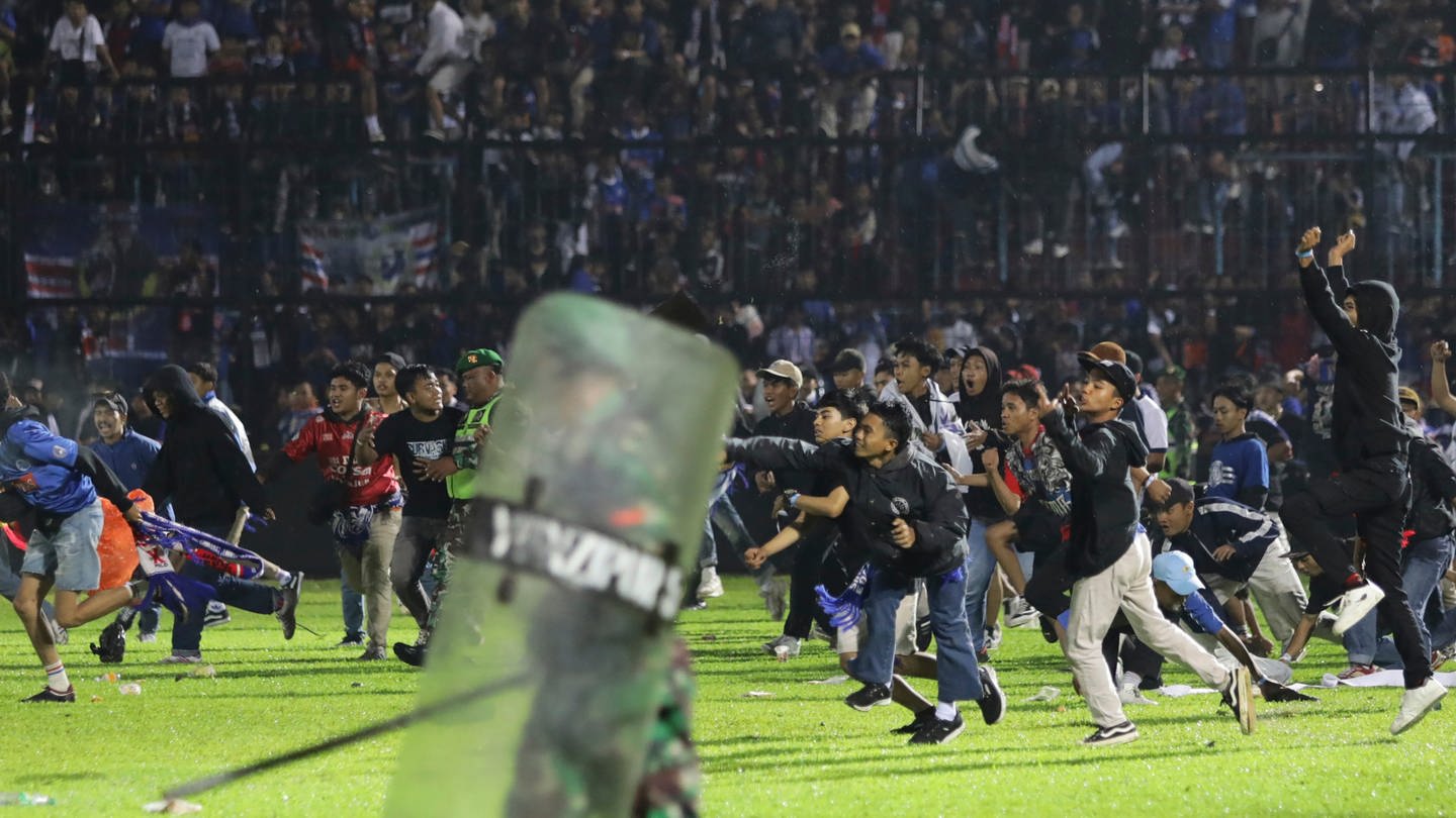 Fußballfans stürmen das Spielfeld während Zusammenstößen zwischen Fans im Kanjuruhan-Stadion nach dem Erstliga-Spiel zwischen Arema FC und Persebaya FC.