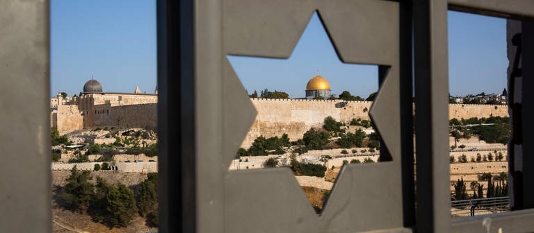 Durch eine Tür mit einem Davidstern ist die Altstadt von Jerusalem (Israel) mit dem Felsendom zu sehen.  (Foto: dpa Bildfunk, picture alliance / Oded Balilty/AP/dpa | Oded Balilty)