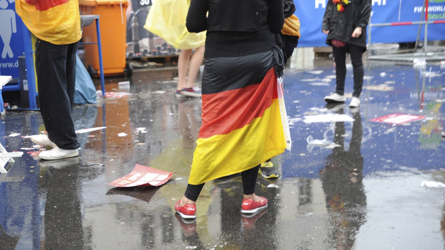 Einsame Fußball-Fans im Regen - kein Public Viewing zur Fußball-EM im Winter 2022. (Foto: IMAGO, IMAGO / Seeliger)