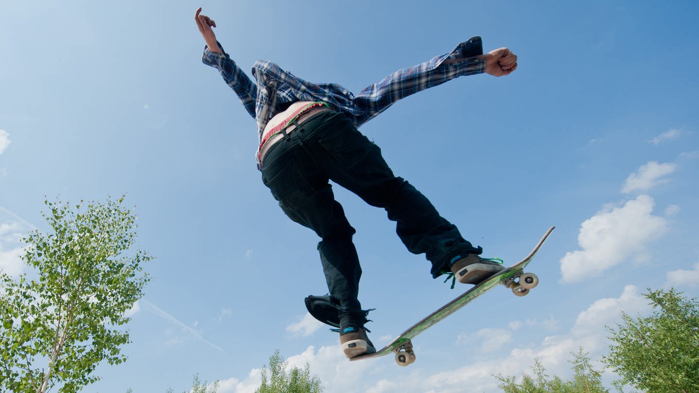 Ein Skateboarder springt über eine Rampe im 