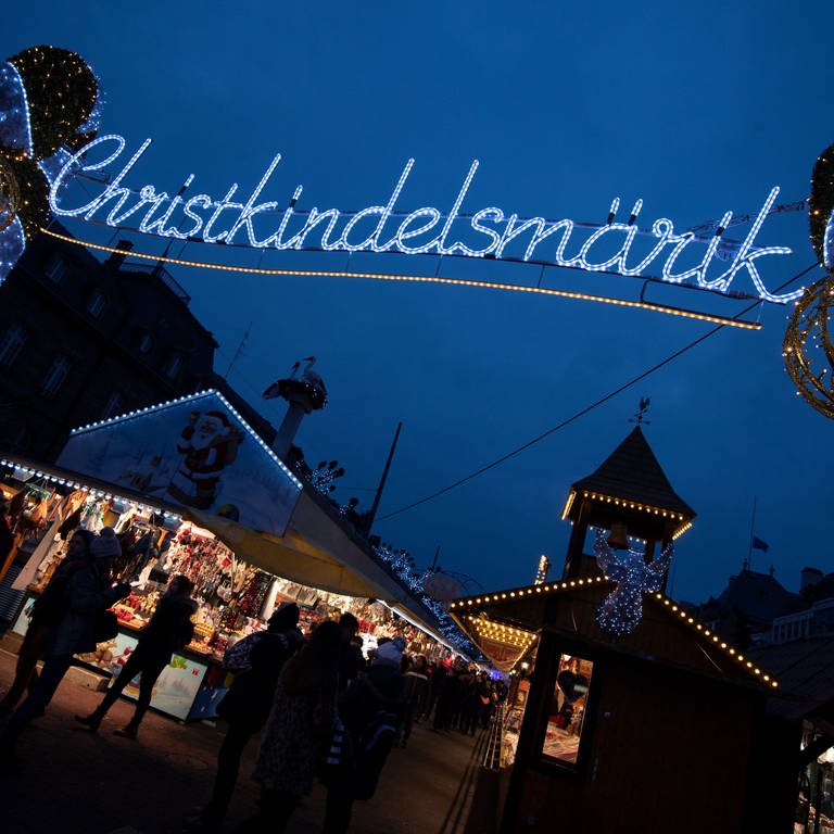 Das Wort "Christkindelsmärik" prangt in großen beleuchteten Buchstaben an einem Zugang zum Weihnachtsmarkt.  (Foto: dpa Bildfunk, picture alliance/dpa | Marijan Murat)