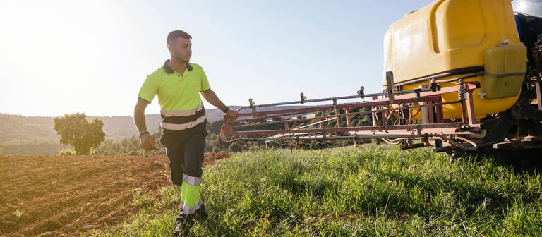 Farmer adjusting crop sprayer on field on sunny day model released, Symbolfoto (Foto: IMAGO, IMAGO / Westend61)