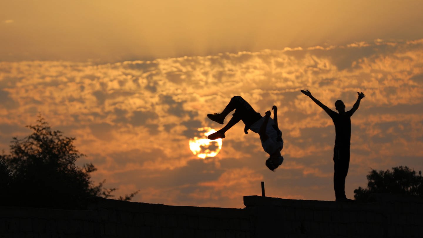 Jugendliche nutzen das letzte Tageslicht für sportliche Aktivitäten. (Foto: dpa Bildfunk, Picture Alliance)