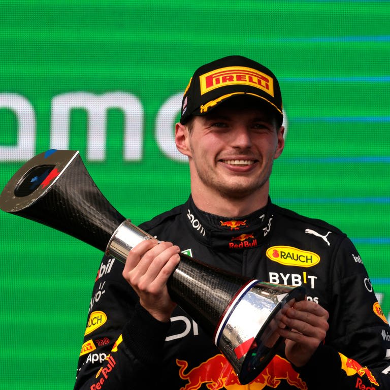Formel-1-Weltmeister Max Verstappen lächelt mit einem Pokal in der Hand bei der Siegerehrung des Großen Preises der USA. (Foto: IMAGO, IMAGO / Motorsport Images)