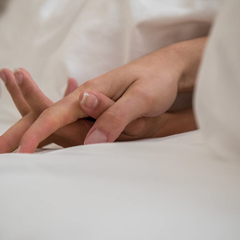 Mann und Frau halten sich an den Händen beim Sex (Foto: dpa Bildfunk, picture alliance/dpa/dpa-tmn | Christin Klose)
