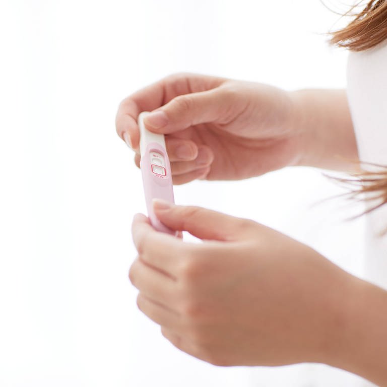 Eine Frau hält einen Schwangerschaftstest in den Händen. (Foto: IMAGO, IMAGO / AFLO)