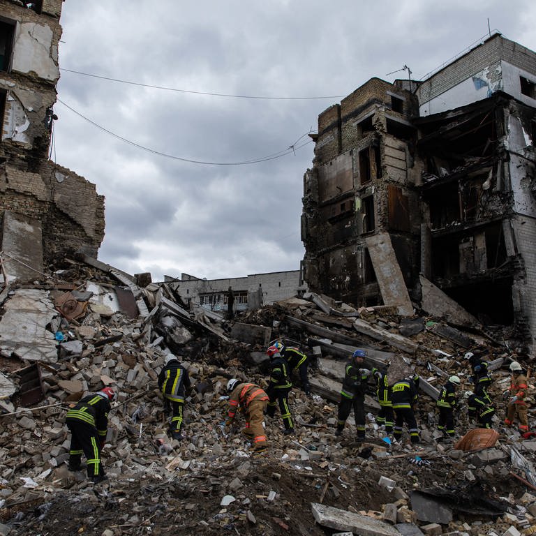 Symbolbild Russland-Ukraine-Krieg: Ukrainische Feuerwehrleute suchen nach Überlebenden unter den Trümmern eines zerstörten Wohnhauses in Borodyanka (Foto: SWR DASDING, picture alliance/dpa/SOPA Images via ZUMA Press Wire | Alex Chan)