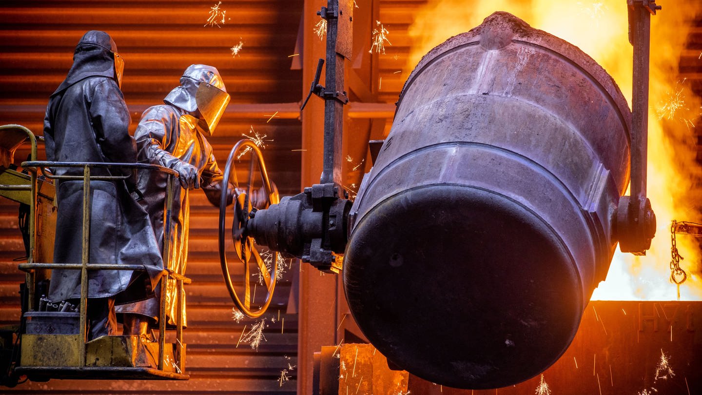 Arbeiter gießen flüssiges Eisen mit einer Temperatur von 1.400 Grad in der Eisengießerei Torgelow in vorbereitete Formen. (Foto: dpa Bildfunk, picture alliance/dpa/dpa-Zentralbild | Jens Büttner)