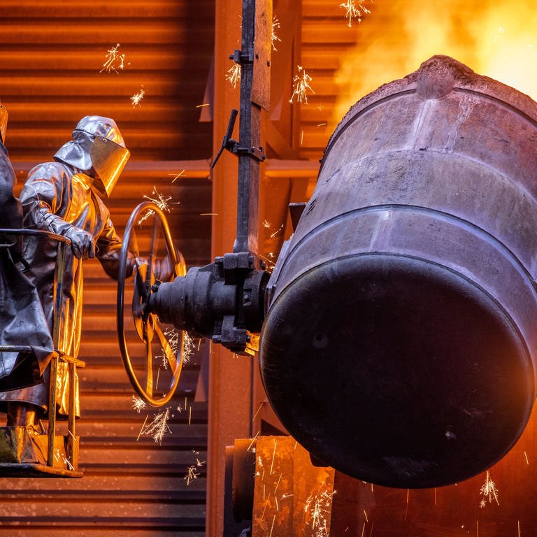 Arbeiter gießen flüssiges Eisen mit einer Temperatur von 1.400 Grad in der Eisengießerei Torgelow in vorbereitete Formen.  (Foto: dpa Bildfunk, picture alliance/dpa/dpa-Zentralbild | Jens Büttner)