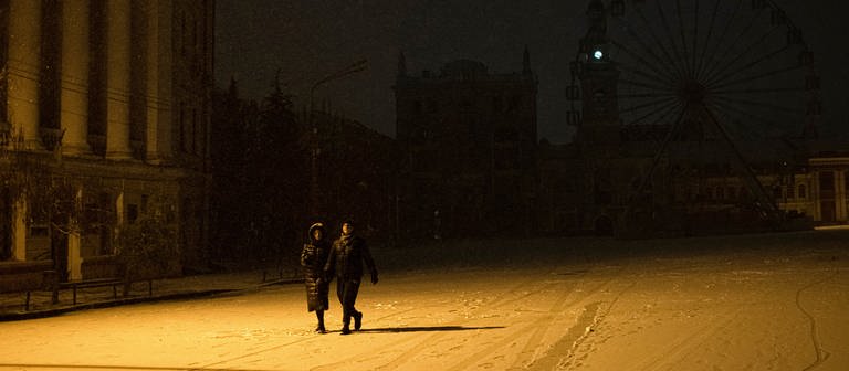 Menschen spazieren durch den Schnee im Stadtzentrum. (Foto: dpa Bildfunk, picture alliance/dpa/AP | Andrew Kravchenko)