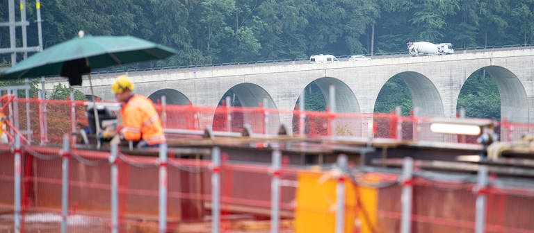 Arbeiter stehen auf der Baustelle der Filstalbrücke, die Teil des Bahnprojektes Stuttgart 21 ist, vor der Todsburgbrücke, über die die A8 führt. (Foto: dpa Bildfunk, Picture Alliance)