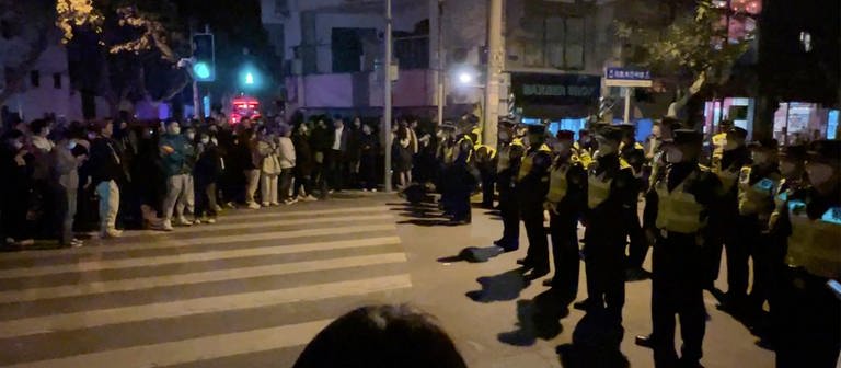 Chinesische Polizisten versperren den Zugang zu einem Platz, an dem sich Demonstranten versammelt hatten. In China hat die strenge Corona-Politik am Wochenende zu den größten Protesten seit Jahrzehnten geführt. In der Hauptstadt Peking und anderen Millionenstädten gingen Demonstranten zu Hunderten auf die Straßen. (Foto: dpa Bildfunk, picture alliance/dpa/AP | ---)