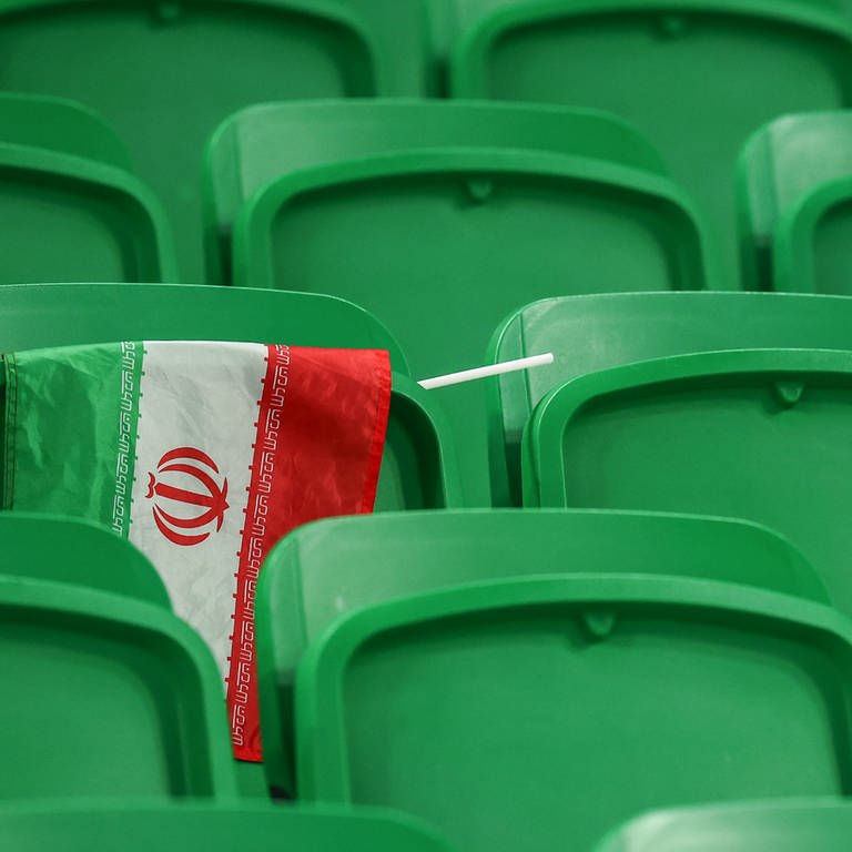 Fußball, WM 2022 in Katar, Iran - USA, Vorrunde, Gruppe B, Spieltag 3 im Al-Thumama Stadion in Doha, Eine iranische Flagge hängt nach dem Spiel über einer Lehne auf der Tribüne. (Foto: dpa Bildfunk, picture alliance/dpa | Christian Charisius)