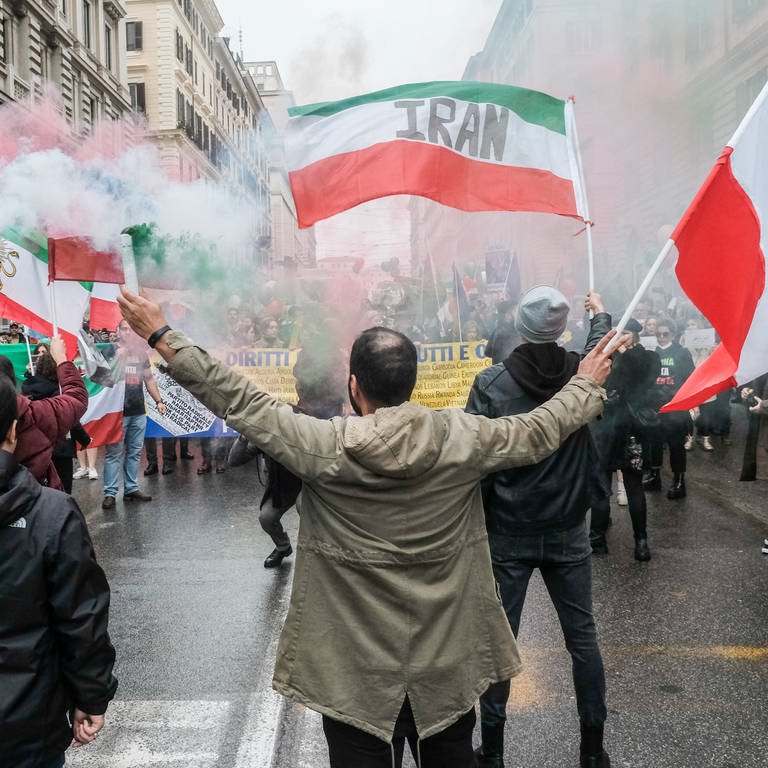 Demonstranten halten während eines Protestes iranische Fahnen und Rauchfackeln. (Foto: dpa Bildfunk, picture alliance/dpa/LaPresse via ZUMA Press | Mauro Scrobogna)