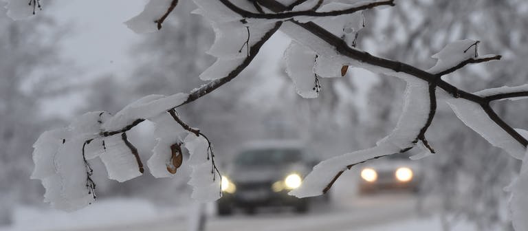 Autos fahren mit eingeschaltetem Licht über eine verschneite Straße. (Foto: dpa Bildfunk, picture alliance/dpa/CTK | Peøina Ludìk)
