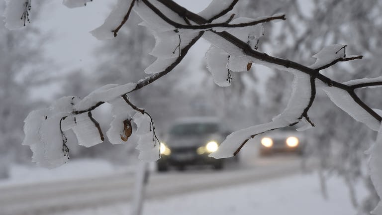 Autos fahren mit eingeschaltetem Licht über eine verschneite Straße. (Foto: dpa Bildfunk, picture alliance/dpa/CTK | Peøina Ludìk)