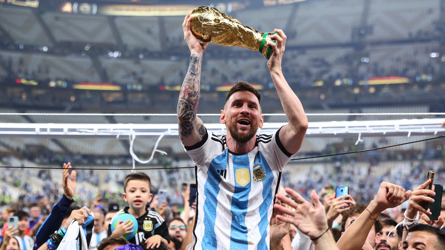 Lionel Messi lässt sich mit dem Weltmeisterpokal durchs Stadion tragen