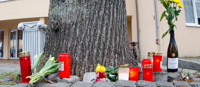 Blumen und Kerzen liegen in der Nähe der Stelle, an der einer ältere Radfahrerin gestürzt war, auf dem Boden. (Foto: dpa Bildfunk, picture alliance/dpa | Heiko Becker)