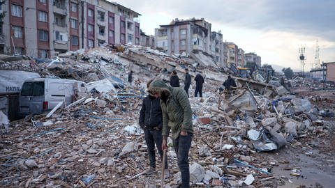 Männer versuchen, in den Trümmern nach Überlebenden des Erdbebens zu suchen (Foto: dpa Bildfunk, Picture Alliance)